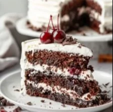 Slice of German Black Forest Cake topped with cherries and whipped cream