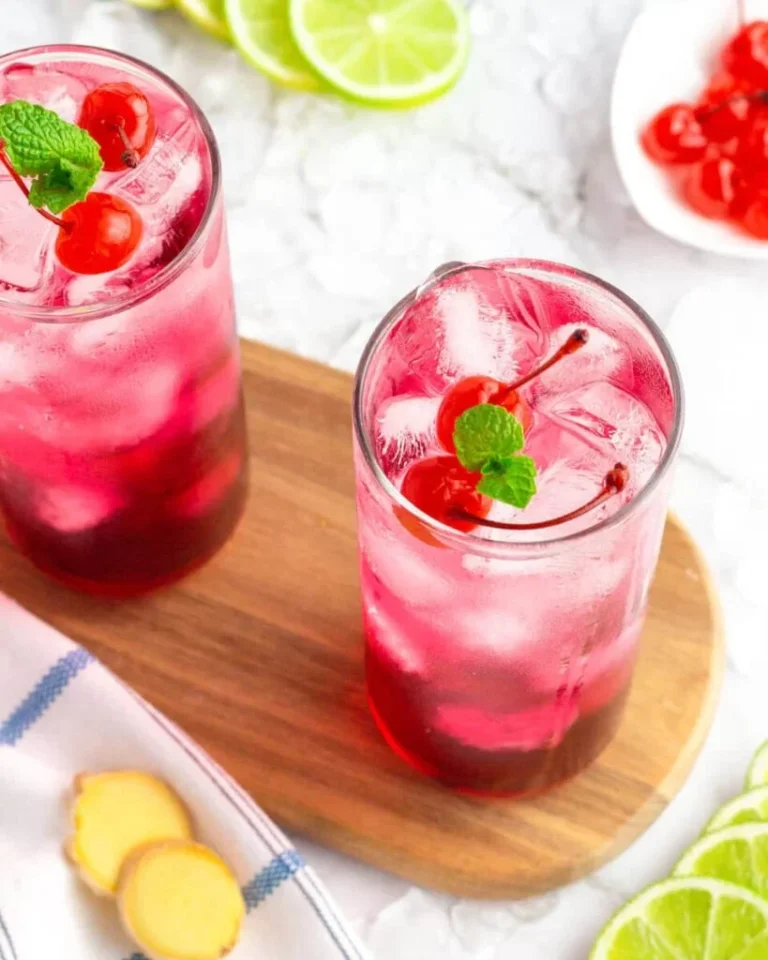 A refreshing ginger ale mocktail served in a glass with ice and garnished with lime.