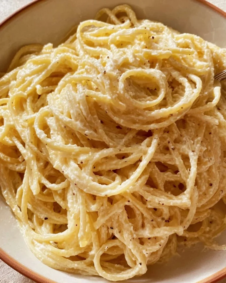 A plate of white spaghetti garnished with herbs and cheese.