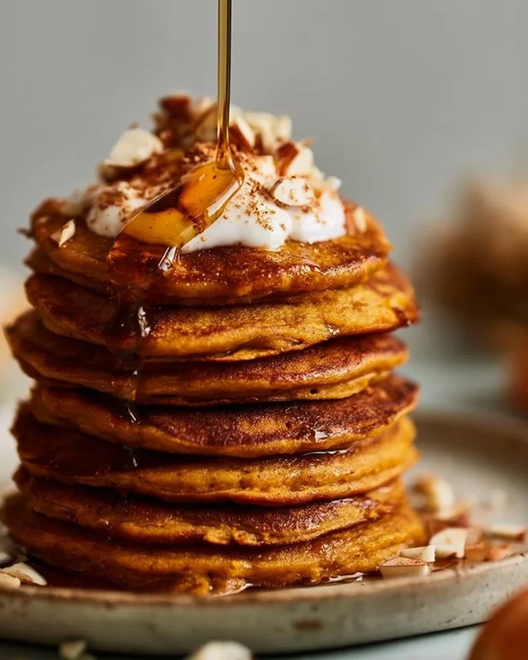 Delicious butternut squash pancakes topped with maple syrup and pumpkin seeds