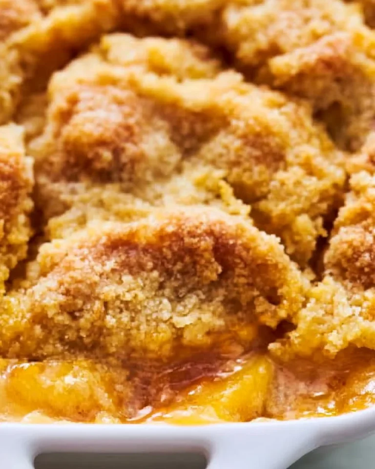 Delicious peach cobbler made with cake mix served in a warm dish.