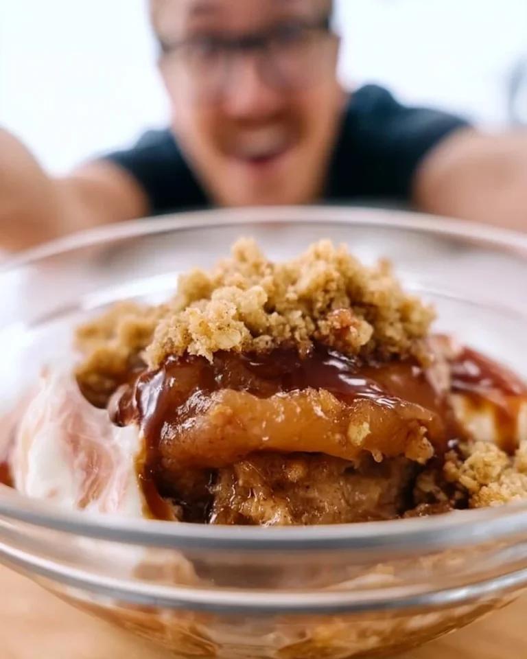 Bowl of delicious vegan apple crisp topped with oats and nuts