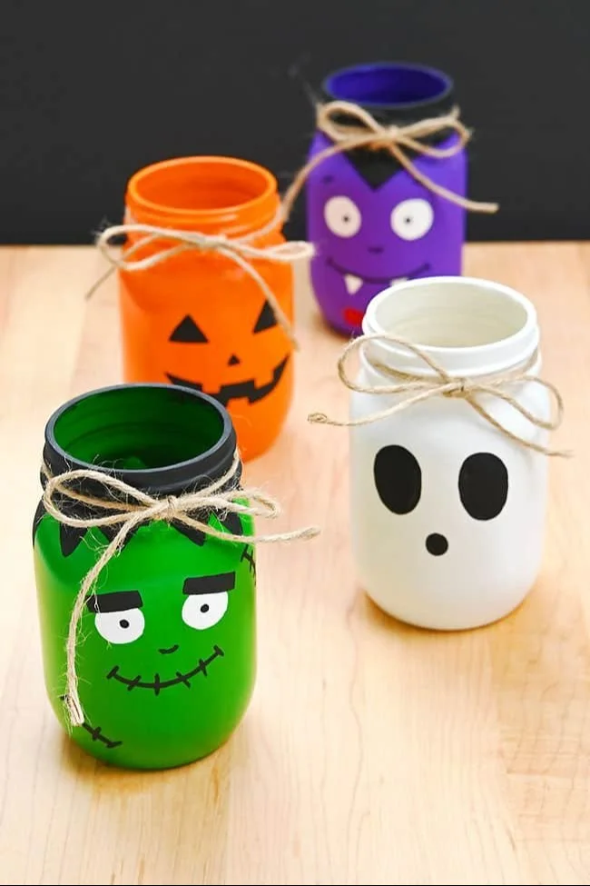 DIY Halloween painted mason jars in various spooky designs.