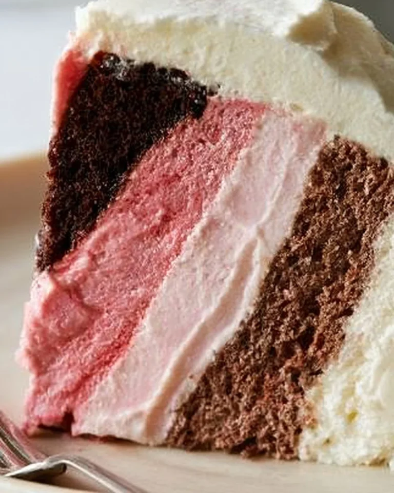 Slice of Neapolitan Cheesecake with chocolate, vanilla, and strawberry layers.